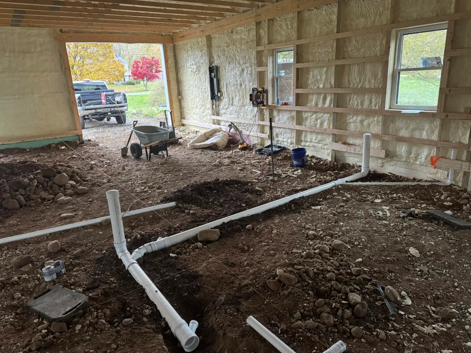 Underground drain lines laid in the dirt floor of a new building before the slab is poured